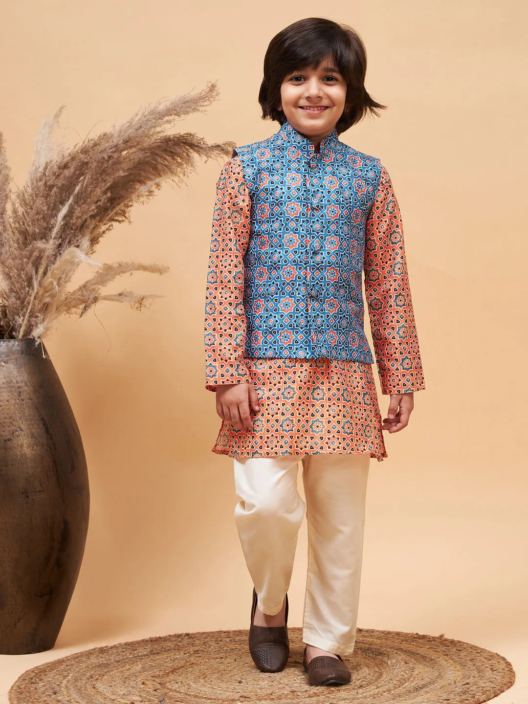 Jashvi Boy's Orange Printed Kurta And Cream Pyjama Set With Blue Nehru Jacket