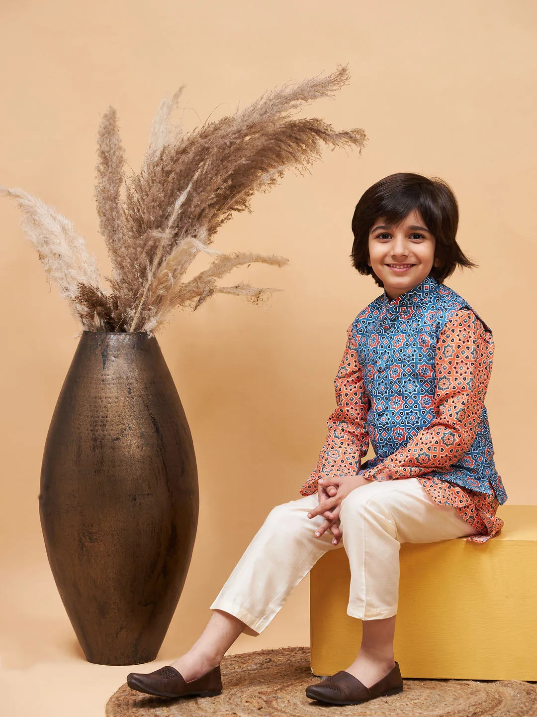 Jashvi Boy's Orange Printed Kurta And Cream Pyjama Set With Blue Nehru Jacket